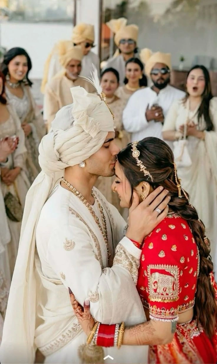 Groom kissing bride on the forehead in a romantic Indian wedding photoshoot