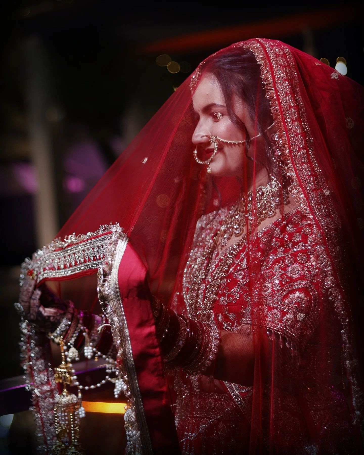 Bride in red bridal lehenga with dupatta veil during wedding shoot