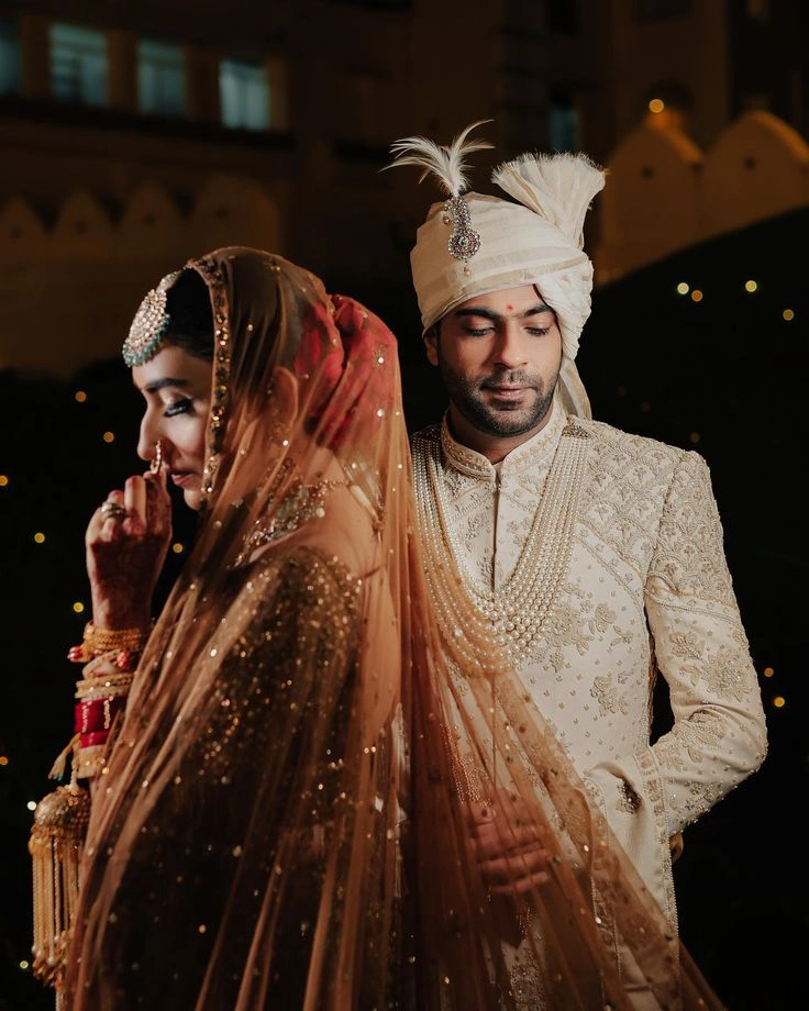 Cinematic Indian bride and groom pose with dramatic lighting and royal wedding styling