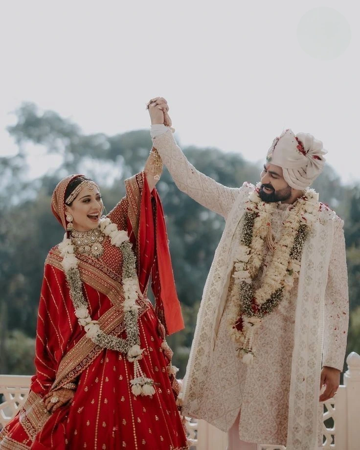 Indian wedding couple celebrating joyfully with dramatic bridal and groom pose