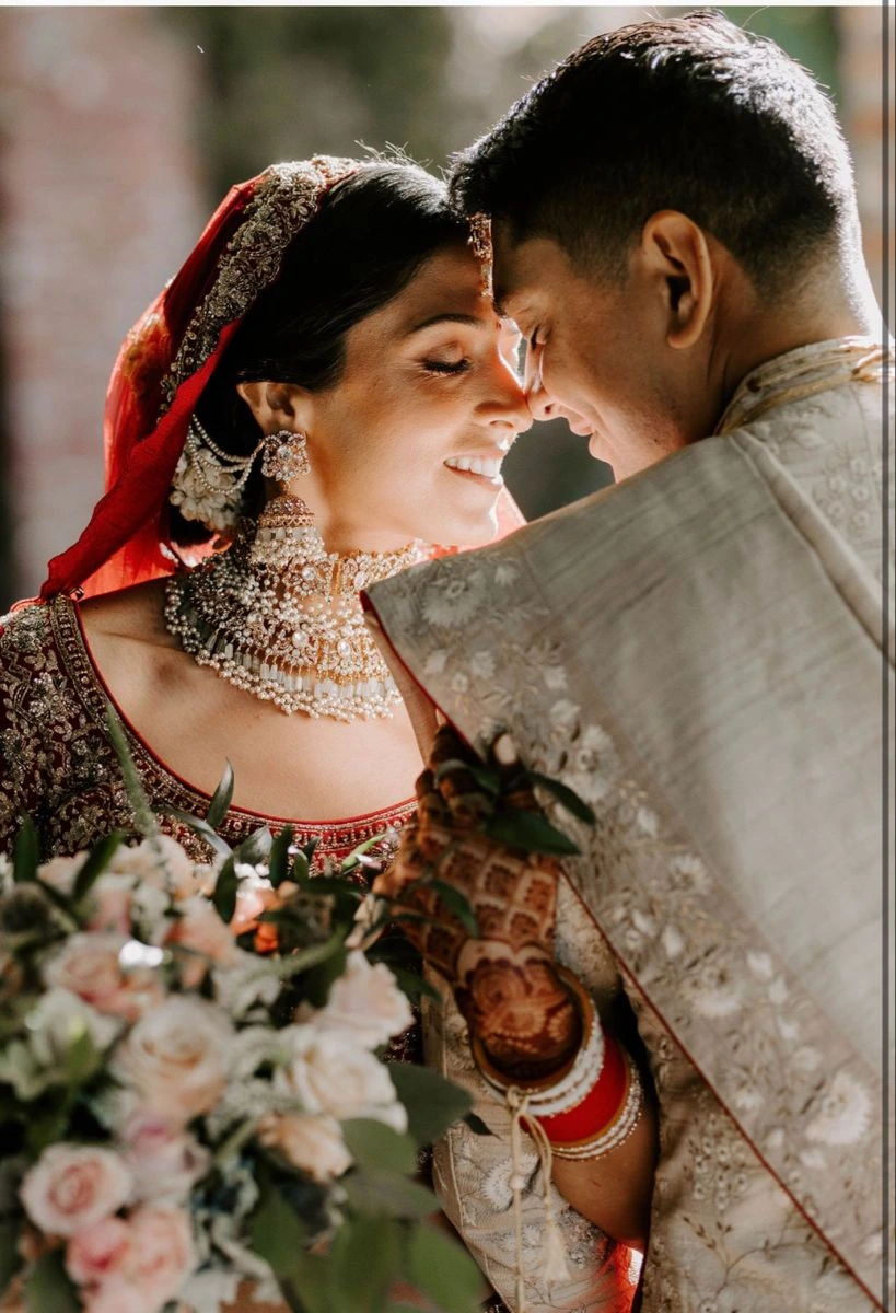 Cute Indian wedding pose with bride leaning on groom in a heartwarming moment