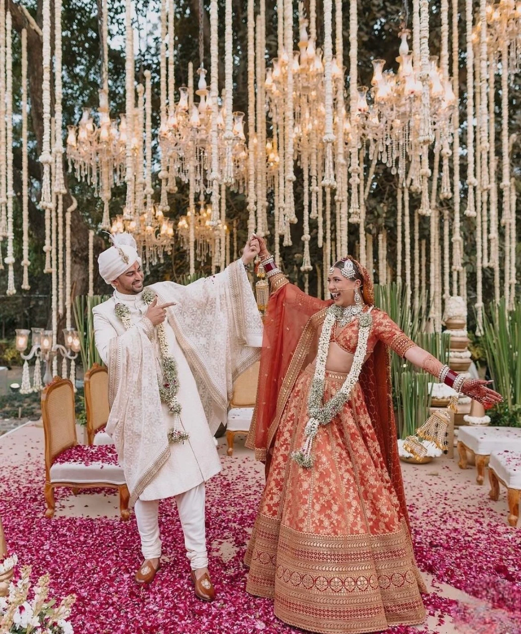Grand bridal and groom pose with floral decor and traditional wedding styling