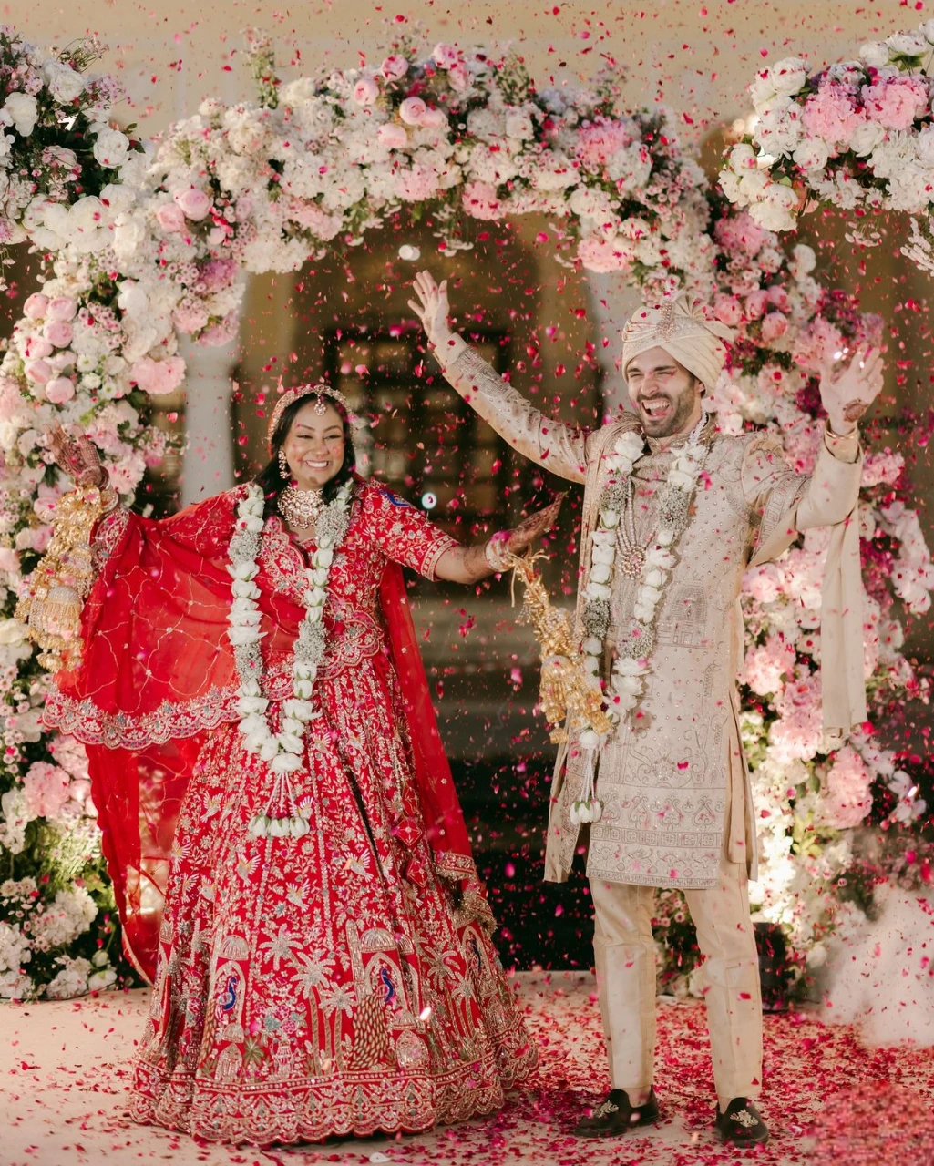 Bride and groom dancing together in a fun candid Indian wedding pose